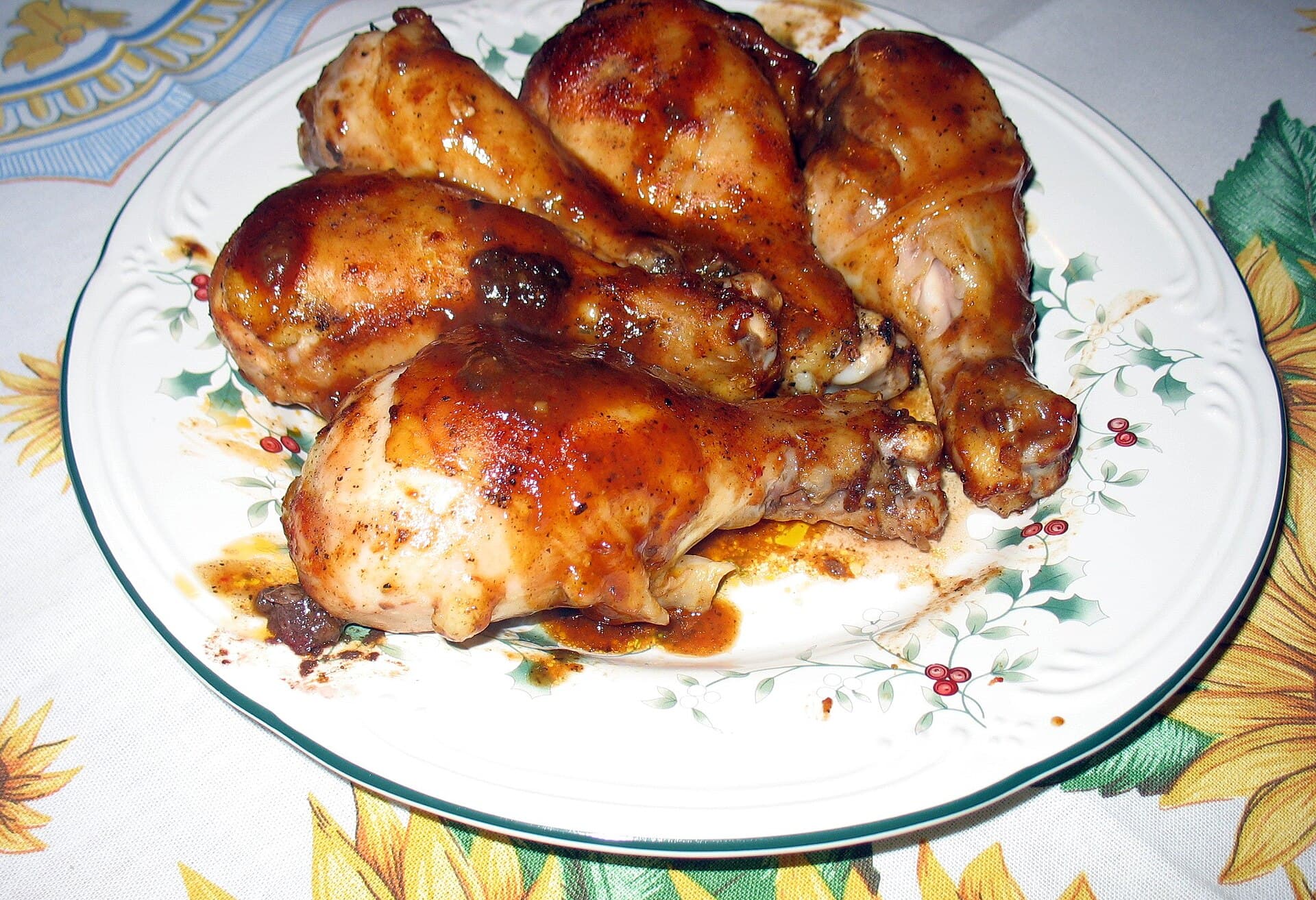A plate of glossy barbecue-glazed chicken drumsticks.